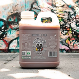 Jug of Melbourne Hot Sauce Chipotle BBQ barbecue sauce with a colourful graffiti wall in the background