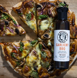 Pizza with slices cut out, featuring a bottle of Grumpy Gary's Garlicky BBQ sauce.
