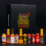 Collection of Hot Ones Season 29 hot sauce bottles in front of a Hot Ones branded box on a black background.