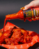 Hot Ones Pickled Garlic Sriracha sauce being poured over fried chicken in a basket - buy online Australia | Blonde Chilli