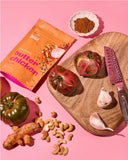 30g sachet of Aunty Jenny Butter Chicken Blend beside a chopping board and tomatoes. Available to buy online in Australia at Blonde Chilli.