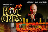 Promotional image for 'Hot Ones' with host Sean Evans eating spicy chicken wings and various Hot Ones exclusive hot sauce bottles. Buy Hot Ones online in Australia at Blonde Chilli.
