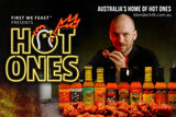 Promotional image for 'Hot Ones' with a person eating spicy food and a row of Hot Ones branded hot sauce bottles. The banner reads "Australia's Home of Hot Ones - blondechilli.com.au