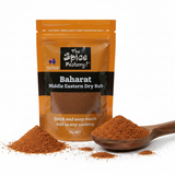 Baharat Middle Eastern Rub packet in background, spoon full of spice blend in the foreground, on a white background.