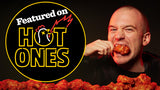 Sean Evans eating hot wings with 'Featured on Hot Ones' logo in the corner