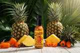 A bottle of Jibba's Tropical Habanero Hot Sauce on a tropical background of pineapples and habaneros.
