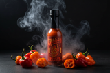 A bottle of Jibba's Smoked Habanero Hot Sauce surrounded by smoking orange & red habaneros