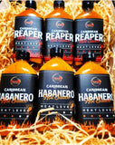 Pepper By Pinard Caribbean Hot Sauces laying in wood wool.