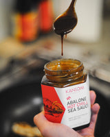 Kansom Australia Abalone Hot Chilli Sea Sauce. Made with Australian Wild Abalone. Spoonful of Sea Sauce dripping into the jar.