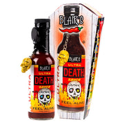 Bottle of Blair's Ultra Death Sauce with dangling skull keyring stands beside its coffin shaped packaging, on a white background.