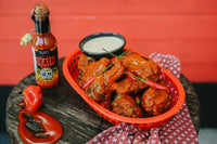 Blair's After Death Sauce sits next to a basket of chicken wings.  Buy hot sauce wholesale and retail in Australia.