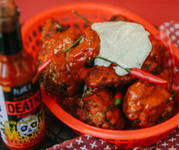 Blair's After Death Sauce sits next to a basket of chicken wings.  Buy hot sauce wholesale and retail in Australia.